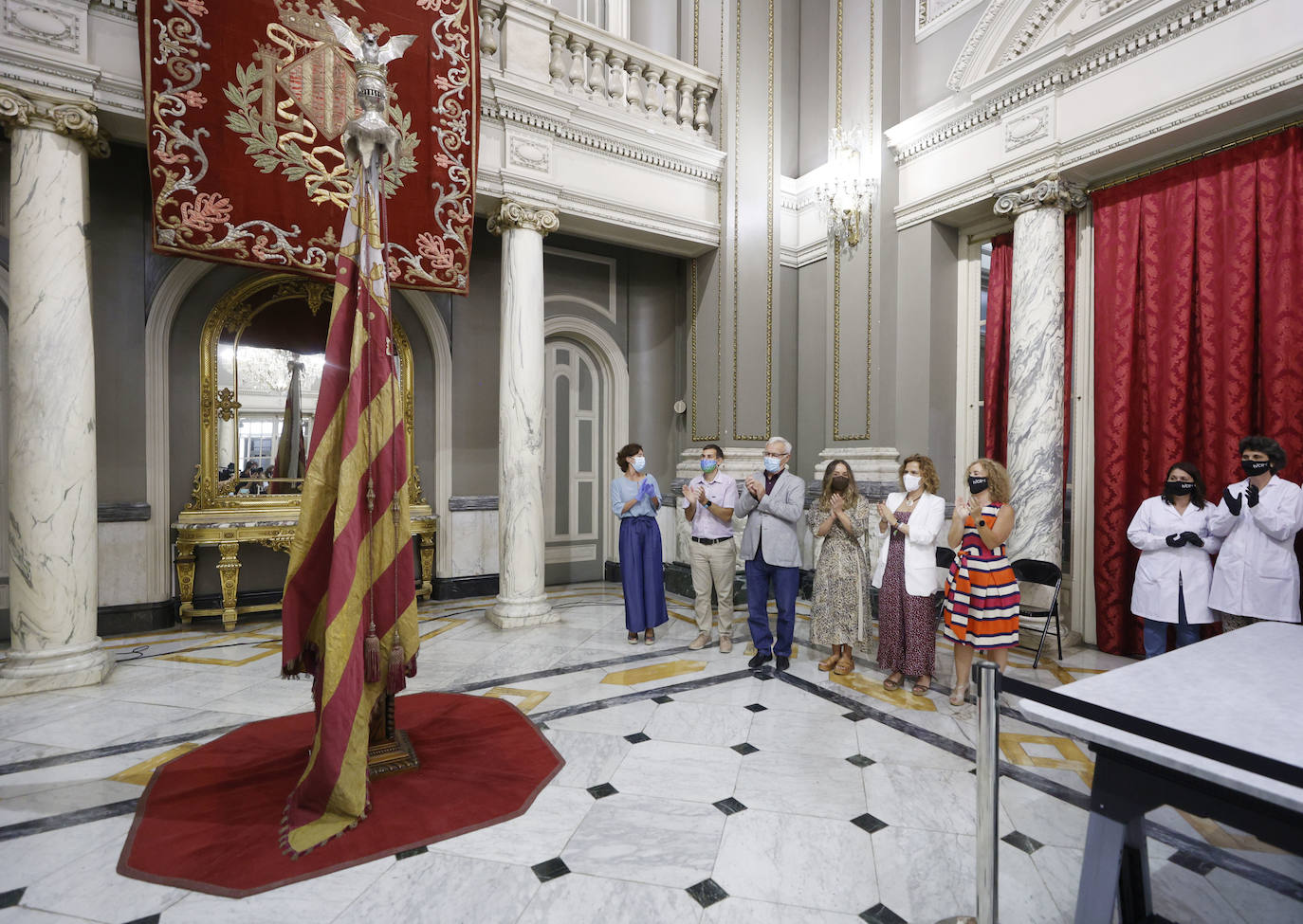 Cuatro meses de restauración devuelven el brillo a la enseña de 1928, que procesionará el 9 d'Octubre. Los expertos comprueban que el azul grisáceo que corona la pieza responde al mismo tono que muestra la bandera del siglo XVI