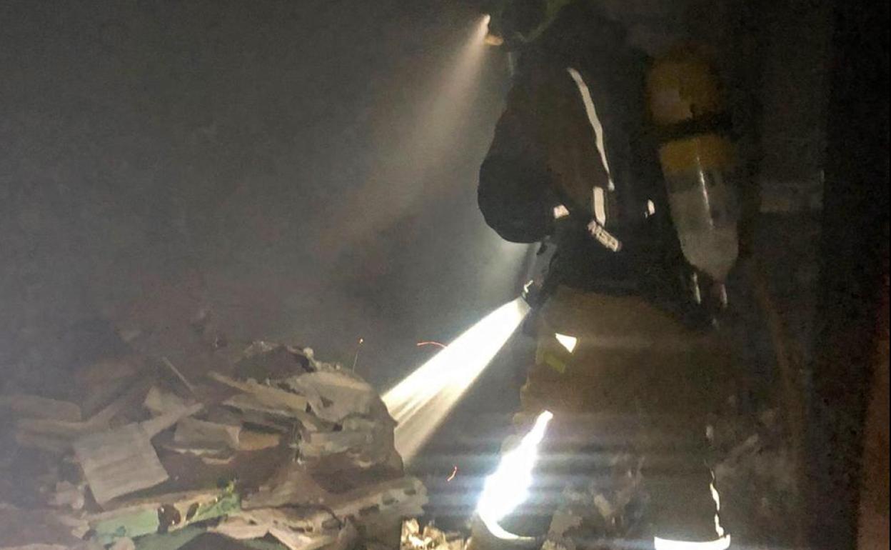 Uno de los bomberos, durante las tareas de extinción del incendio en la vivienda de Elda. 