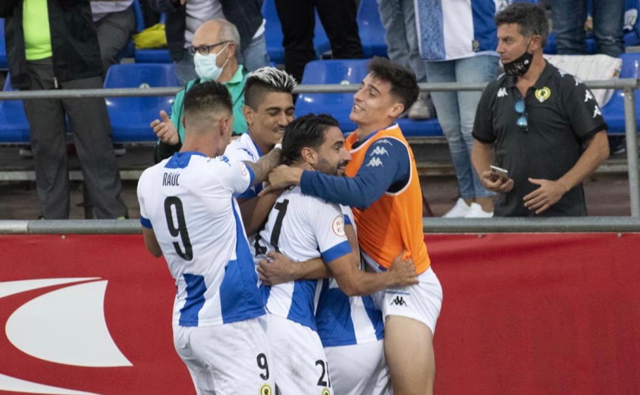 Los jugadores blanquiazules abrazan a Pedro Sánchez después de anotar el 0-2 ayer en Pulpí. 