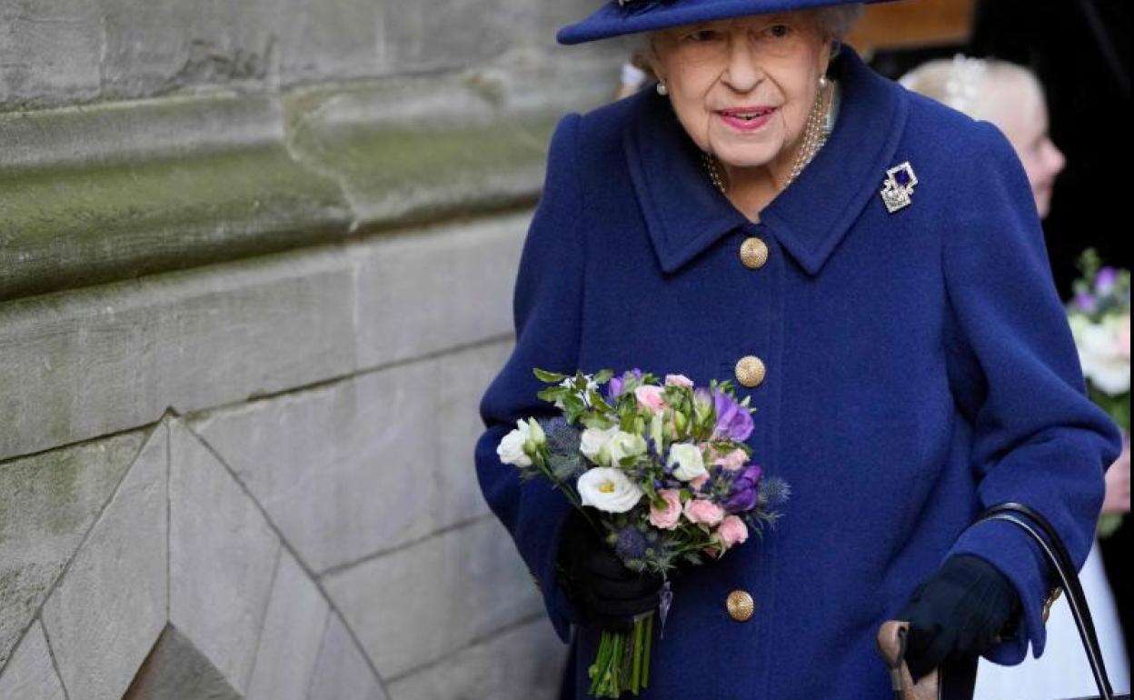 Isabel II, con un bastón en su mano izquierda. 