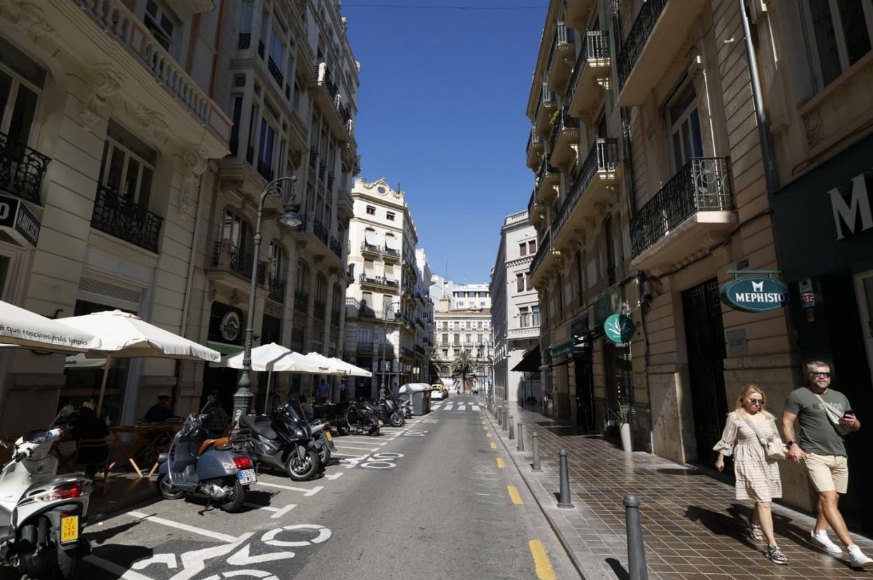 Una pareja circula ayer por la calle Lauria, en el centro de Valencia. iván arlandis