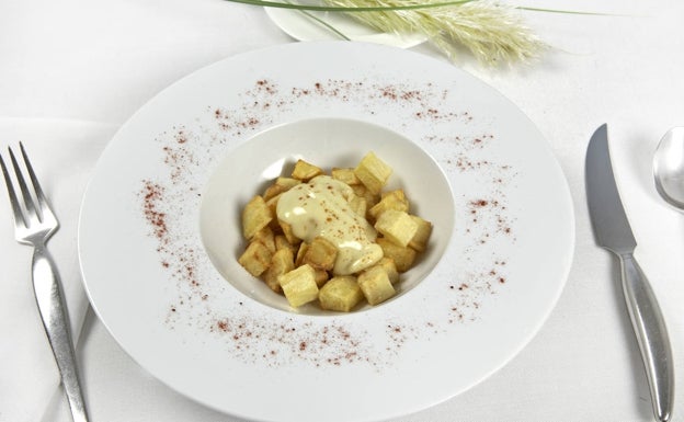 Imagen principal - Arriba, plato de patatas bravas del restaurante Askua. Abajo a la izquierda, receta del cremaet de bravas de La Aldeana. Abajo a la derecha, plato de bravas del restaurante Doña Petrona.