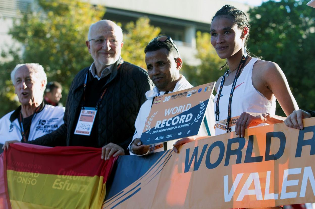 Gidey, con el cartel que le acredita como la más rápida del medio maratón, junto a Juan Roig y Paco Borao. EFE/MIGUEL ÁNGEL POLO