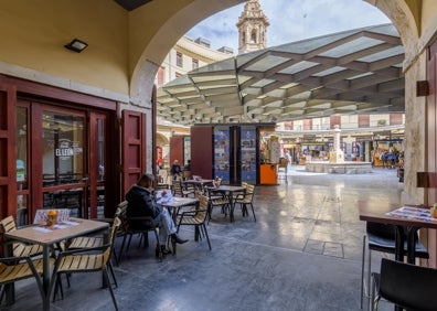 Imagen secundaria 1 - Arriba, estanterías de la cervecería Cervezas del Mercado de Colón. Abajo a la izquierda, la terraza del bar El León, con la Plaza Redonda al fondo. Abajo a la derecha, una mujer tira una cerveza en uno de los dieciocho grifos de Cervezas del Mercado de Colón.