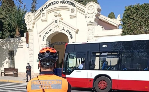 Un miembro de protección civil vigila el acceso al cementerio. 