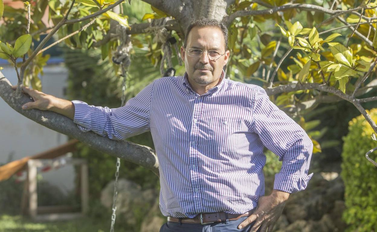 Vicente Martínez, apoyado en las ramas de un árbol de su chalé. 