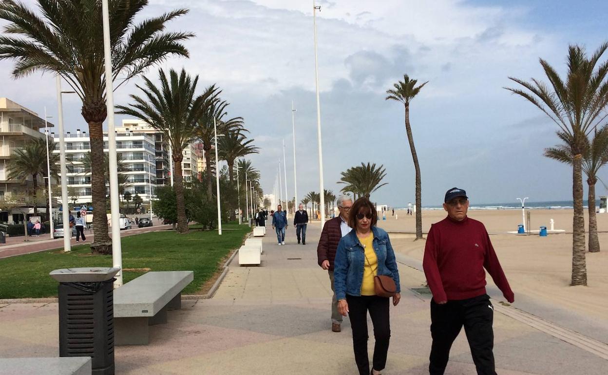 Un grupo de turistas camina por el paseo marítimo de la playa de Gandia. 