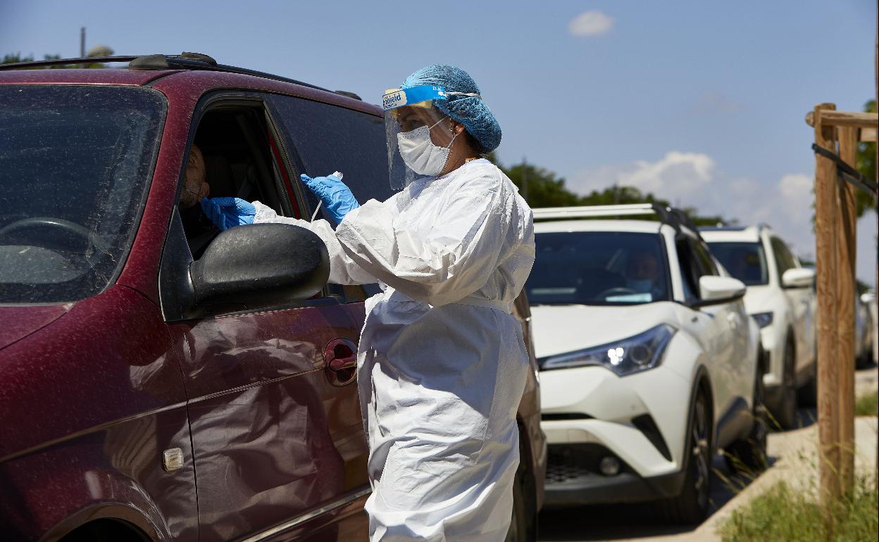 Una sanitaria realiza una PCR a una persona en las inmediaciones de la Fe en Valencia. 