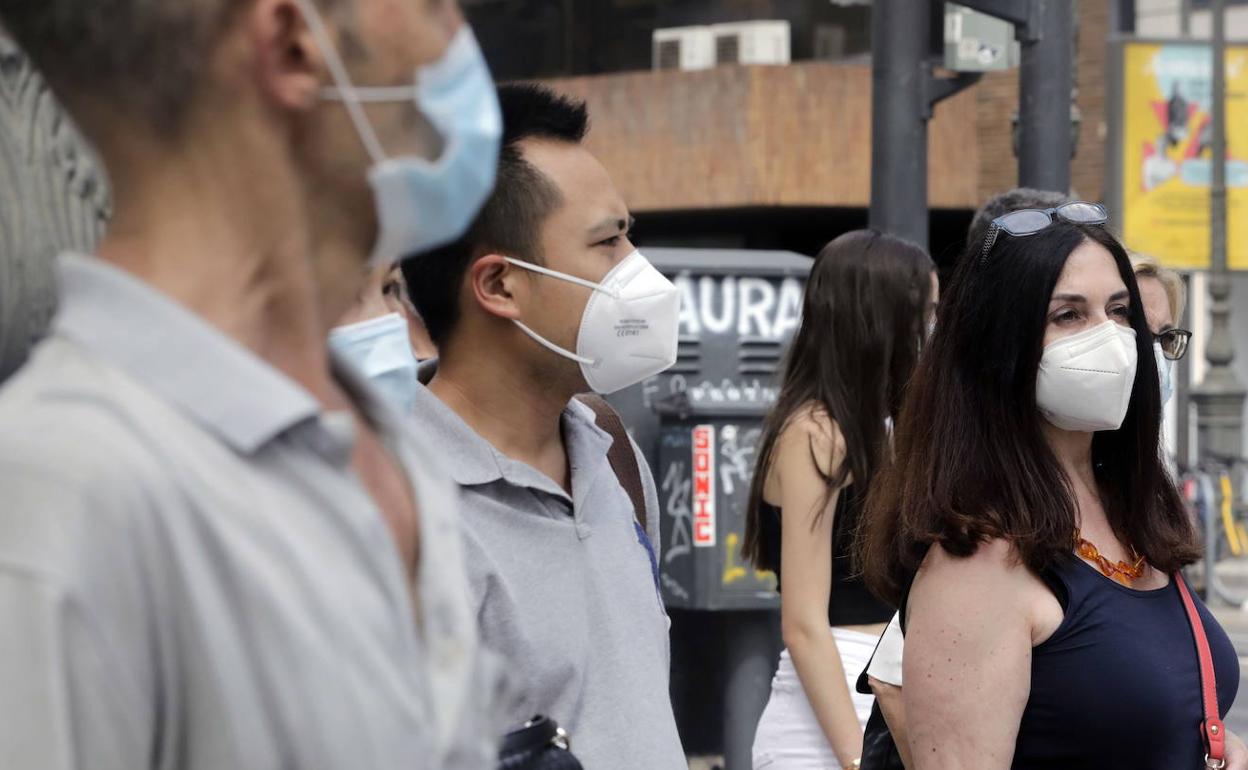 Varias personas con mascarilla en Valencia. 