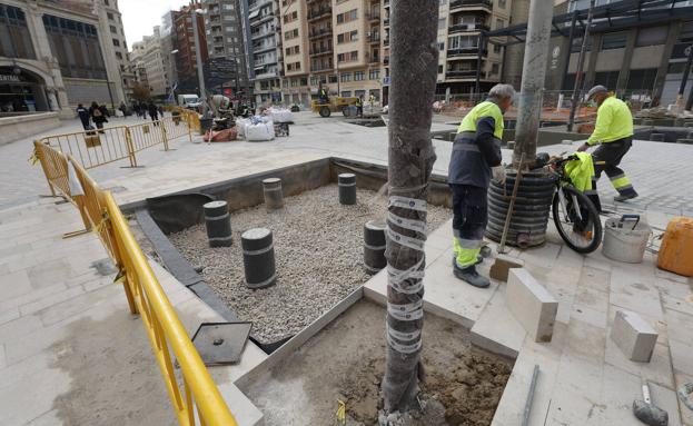 Dos operarios trabajan en la intervención de la plaza de Brujas. 