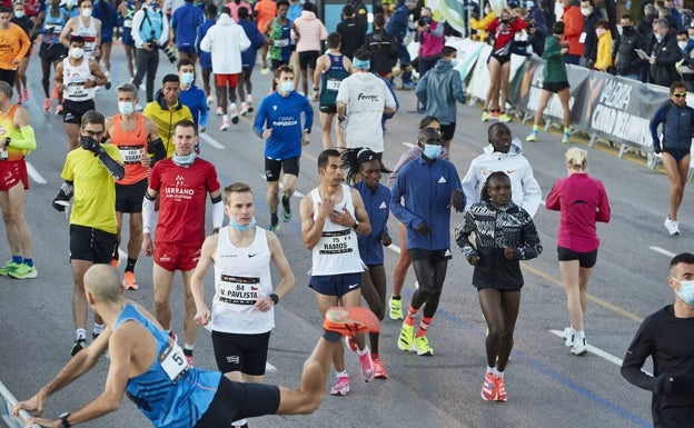 Participantes de la anterior edición del maratón Valencia, calientan cerca de la línea de salida. 