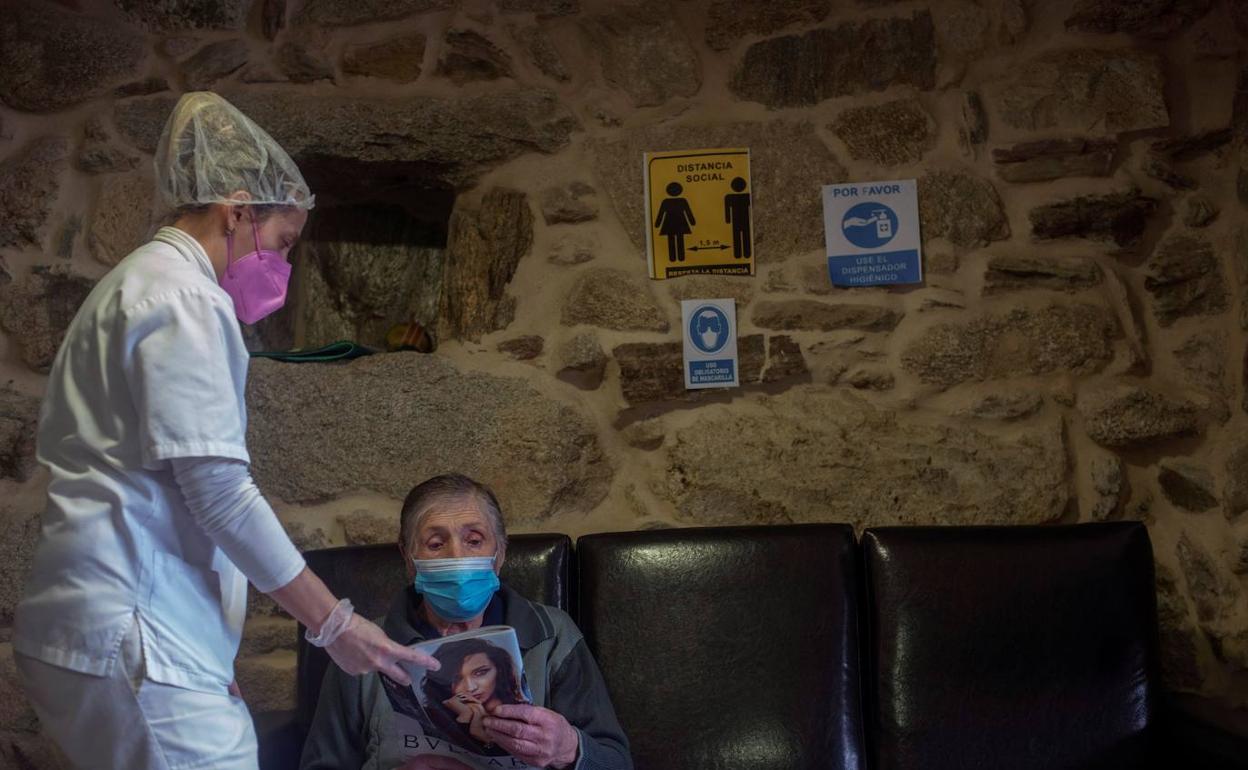 Una enfermera atiende a una anciana. 