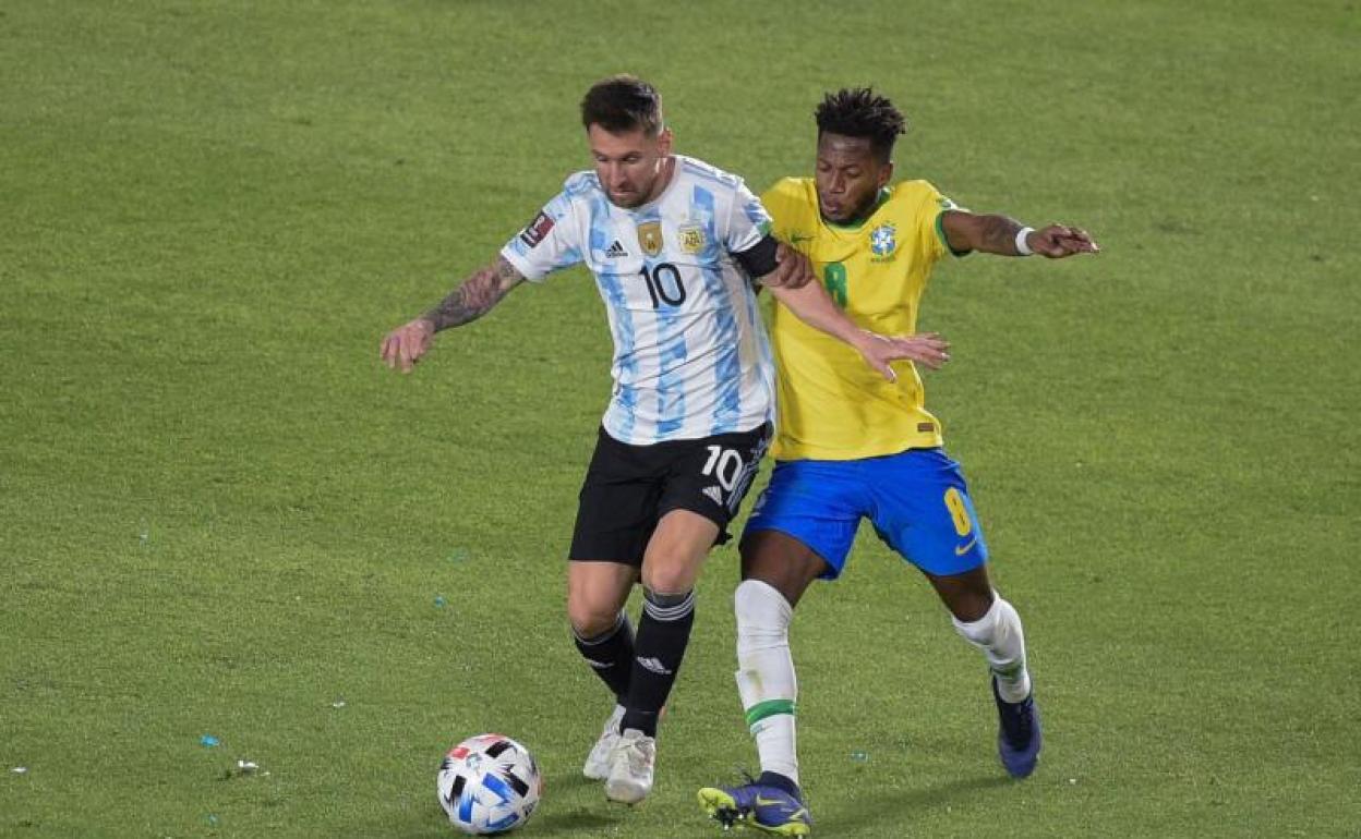 Leo Messi pugna con Fred durante el partido entre Argentina y Brasil del martes. 