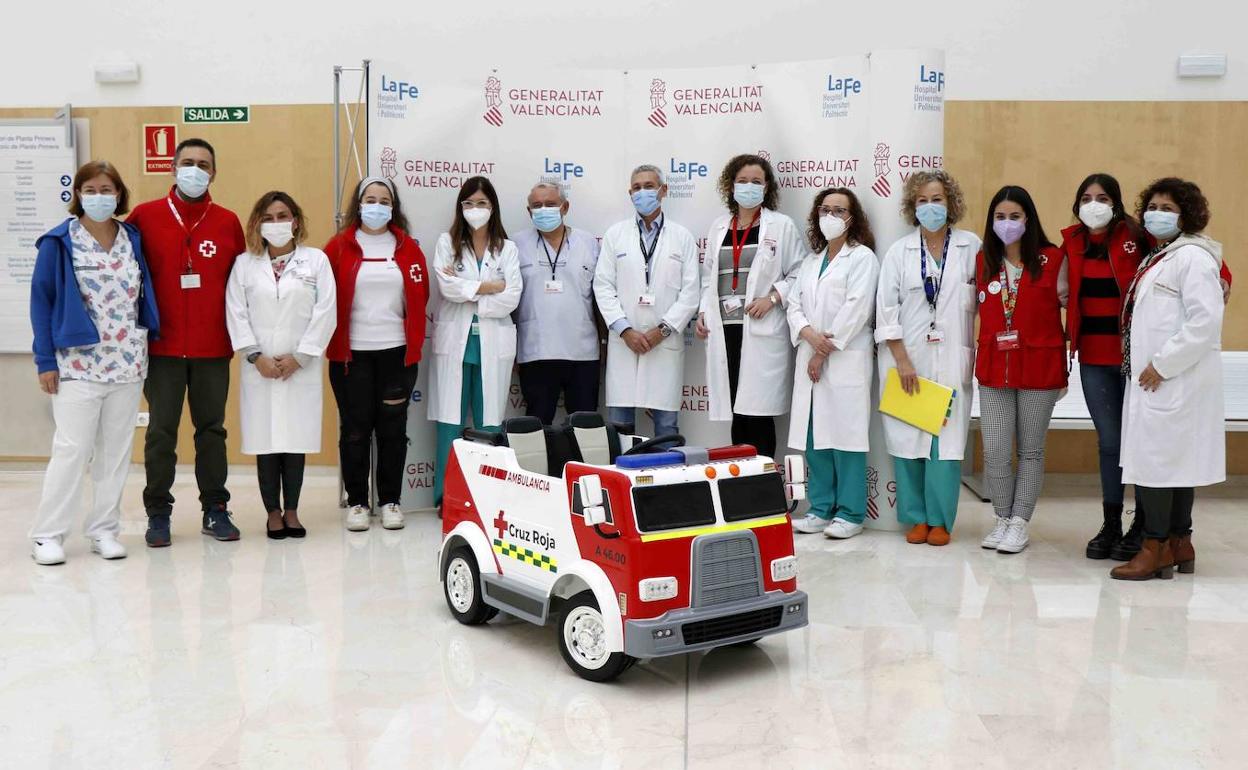 Personal sanitario y miembros de Cruz Roja con la ambulancia donada por la ONG.