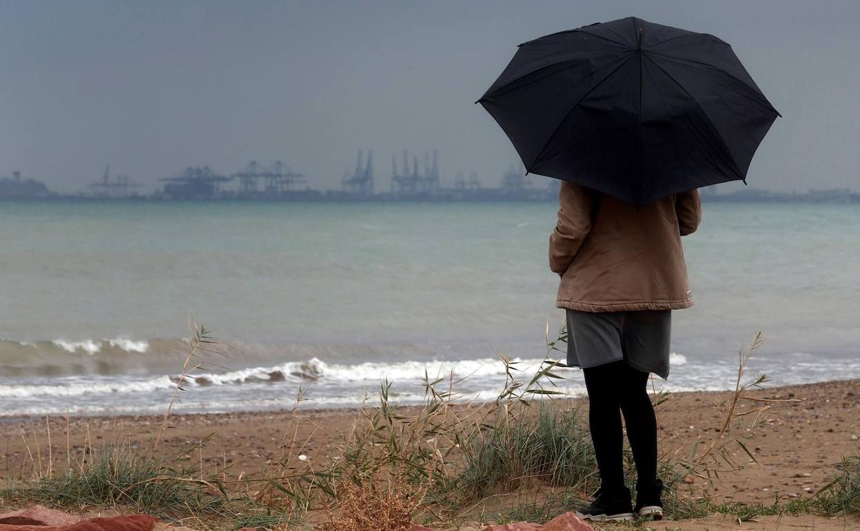 Una mujer bajo la lluvia este sábado en Valencia. 