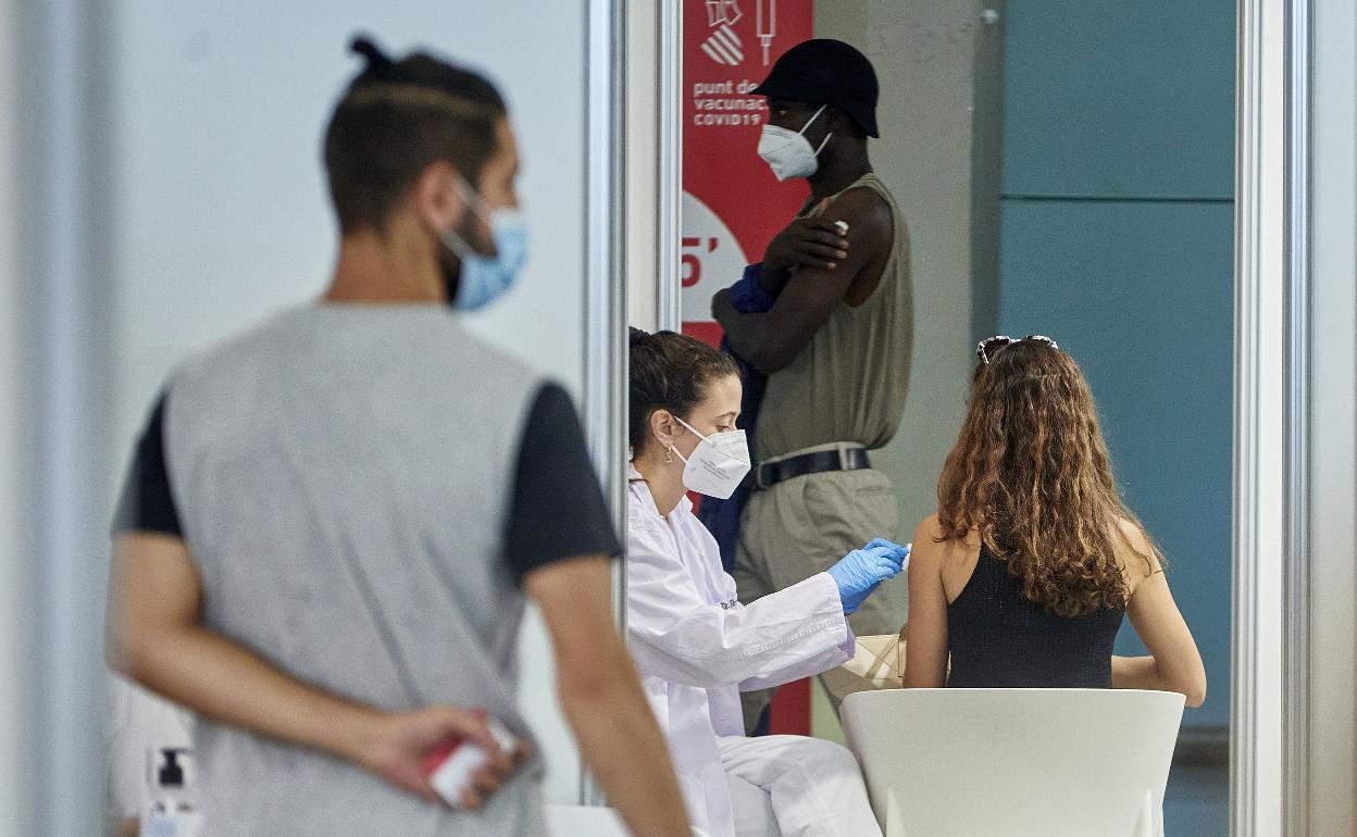 Una sanitaria vacuna a una joven en la Ciudad de las Artes y las Ciencias. 