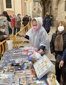 Imagen secundaria 2 - El arzobispo de Valencia, Antonio Cañizares, en el Besamanos; colas en el exterior y mesa de Seguidores de la Virgen. 