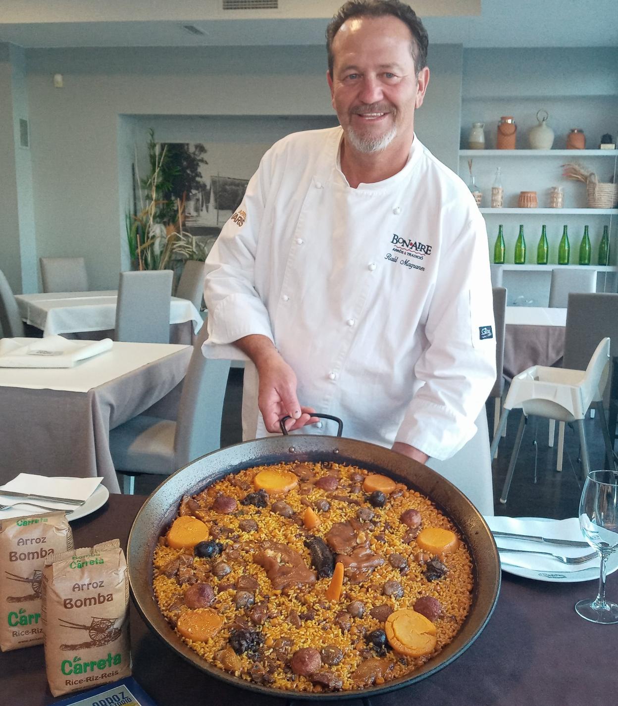 El cocinero Raúl Magraner
junto a la paella de Alzira. LP