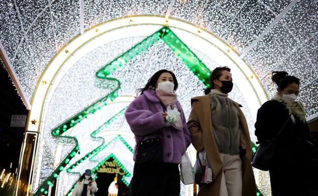 Varias personas, en una zona con decoración navideña en Seúl, Corea del Sur.