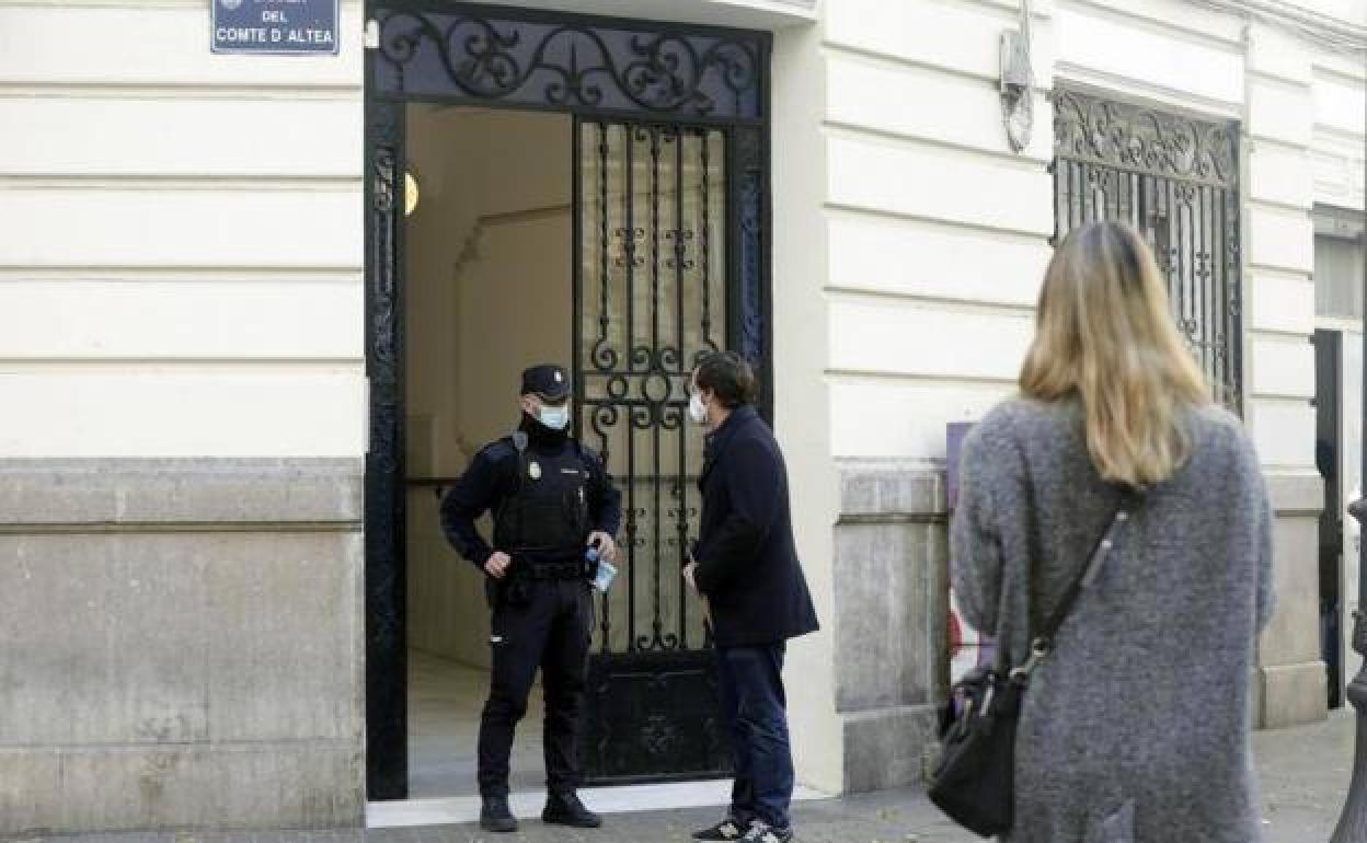 Un agente de policía custodia la entrada del patio.