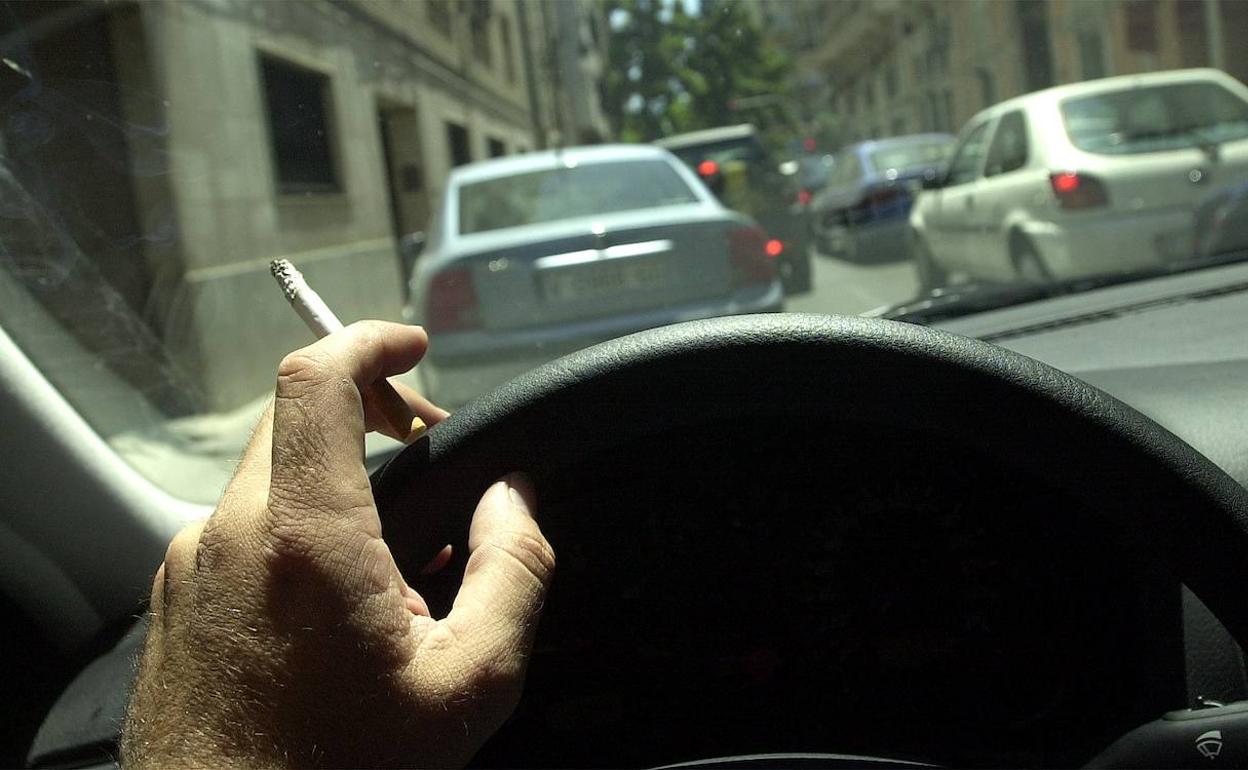 Un conductor fuma en el coche. 