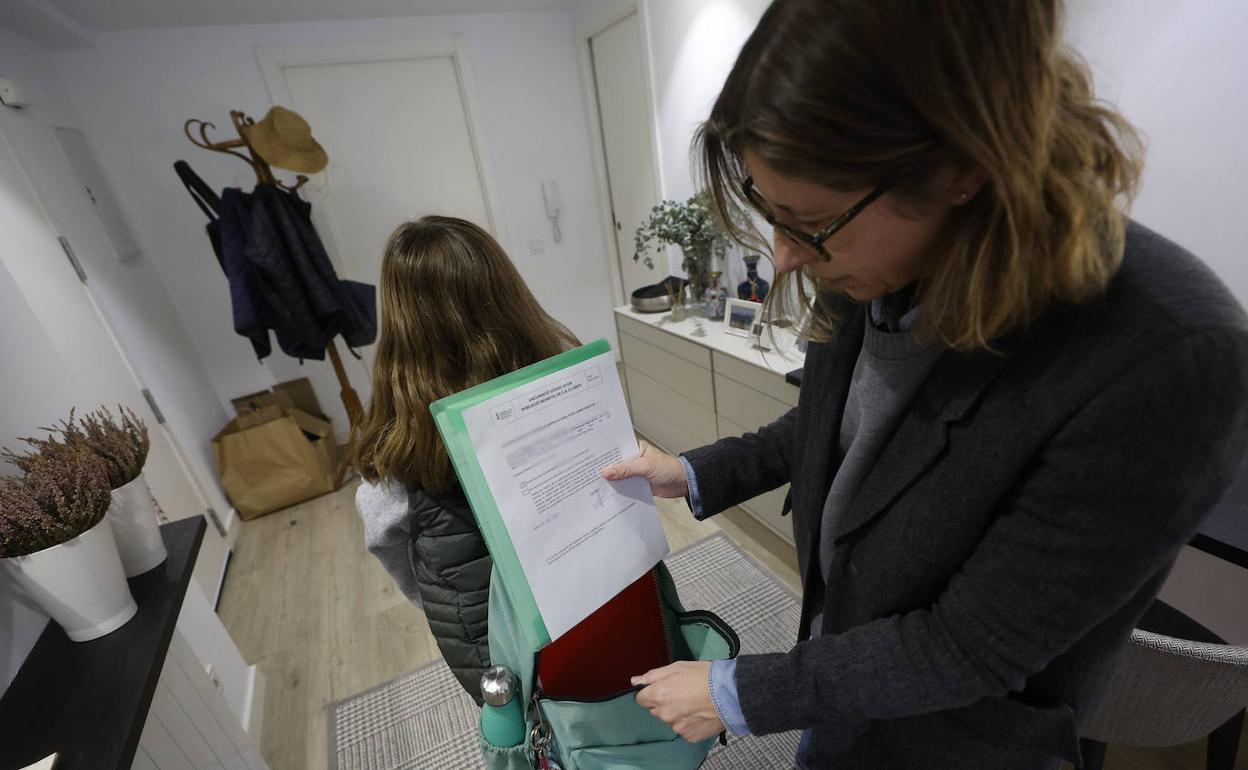 Adela Doménech introduce la autorización en la mochila de su hija, este martes. 