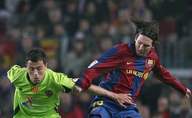 Javi Fuego durante su etapa en el Levante pelea un balón con Lionel Messi. 