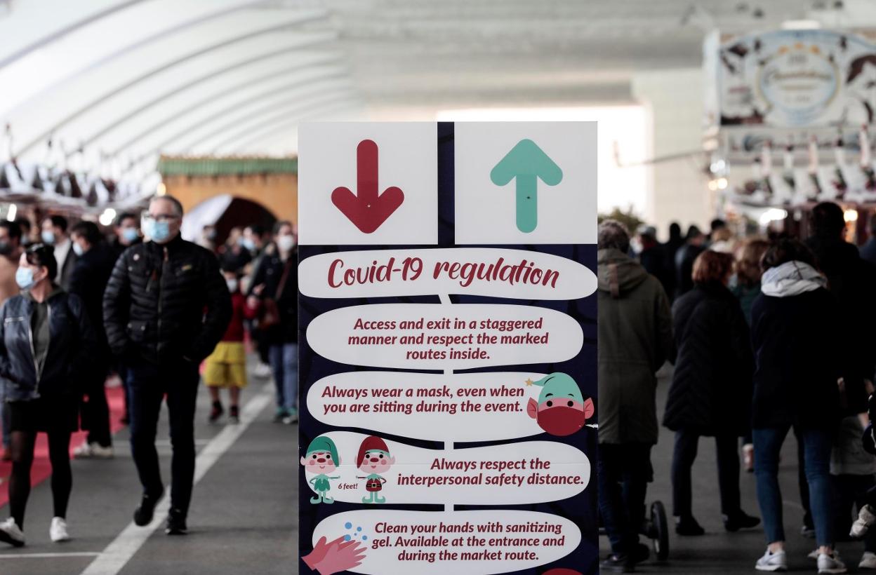 Decenas de personas pasean por un mercadillo navideño situado en la Ciudad de las Artes y las Ciencias de Valencia, este domingo. 