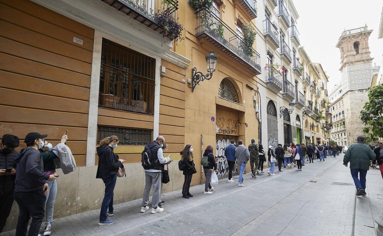 Decenas de personas hacen cola en el punto de vacunación sin cita instalado en la plaza de Manises de Valencia.