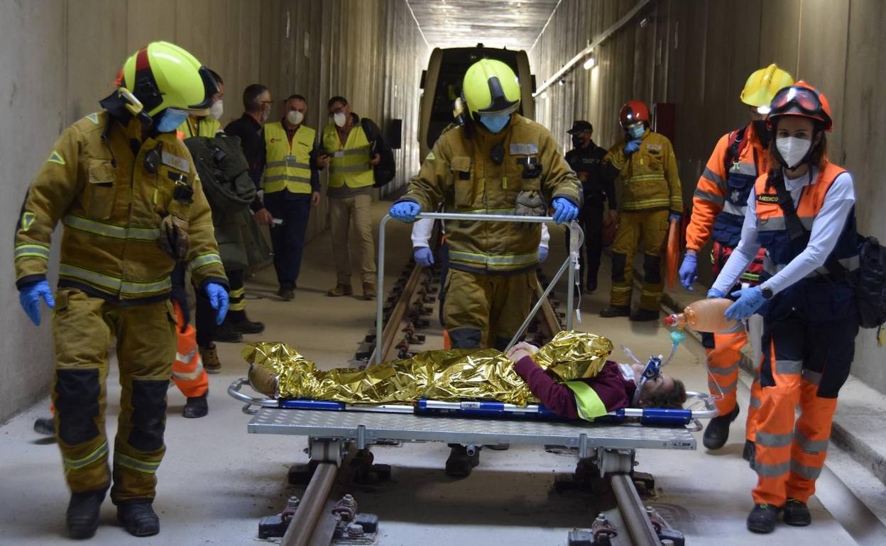 Efectivos de emergencias llevando a un herido durante el simulacro en un túnel del TRAM entra Gata y Teulada. 