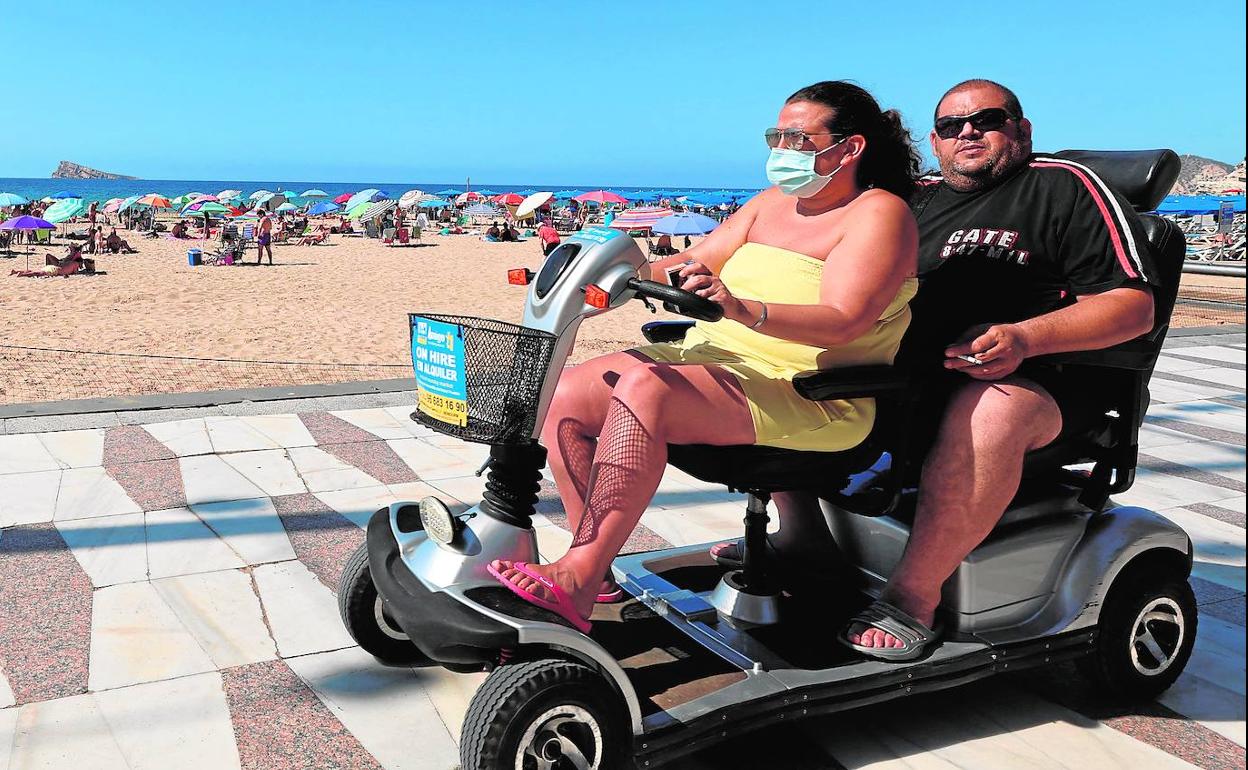 Dos turistas en el paseo marítimo de Benidorm. 