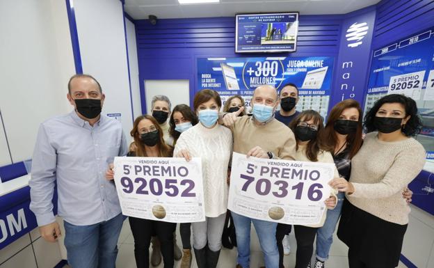 Trabajadores y vecinos de una administración de Manises, celebran la venta de dos de los quintos premios. 