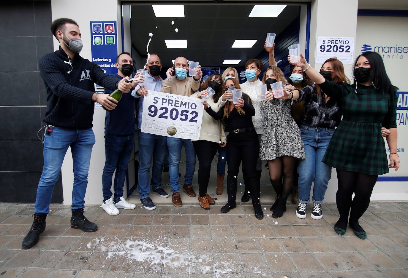 Trabajadores y vecinos de la administración número 3 de Manises, sita en la calle Maestro Guilen, que ha vendido una de las series del 92.052, lo que supone 60.000 euros en premios celebran el premio