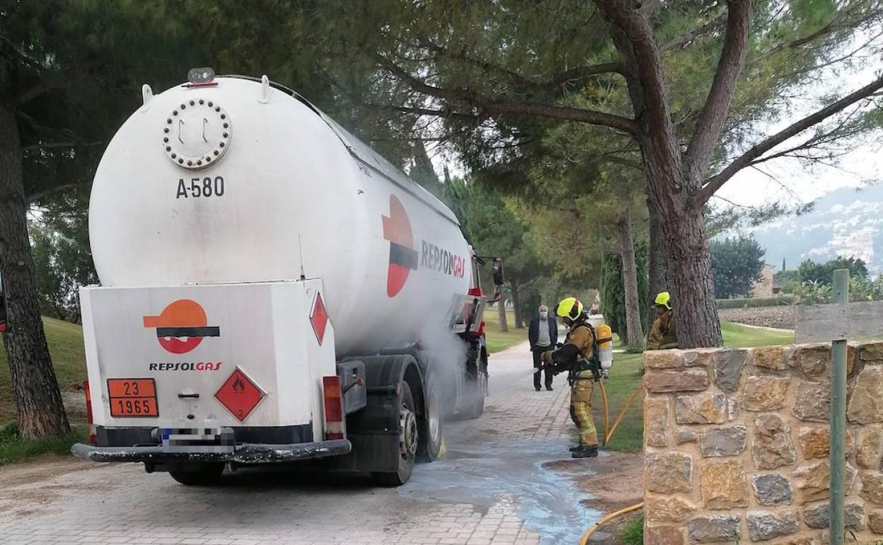 Bomberos refrescando la parte del camión afectada por el fuego. 