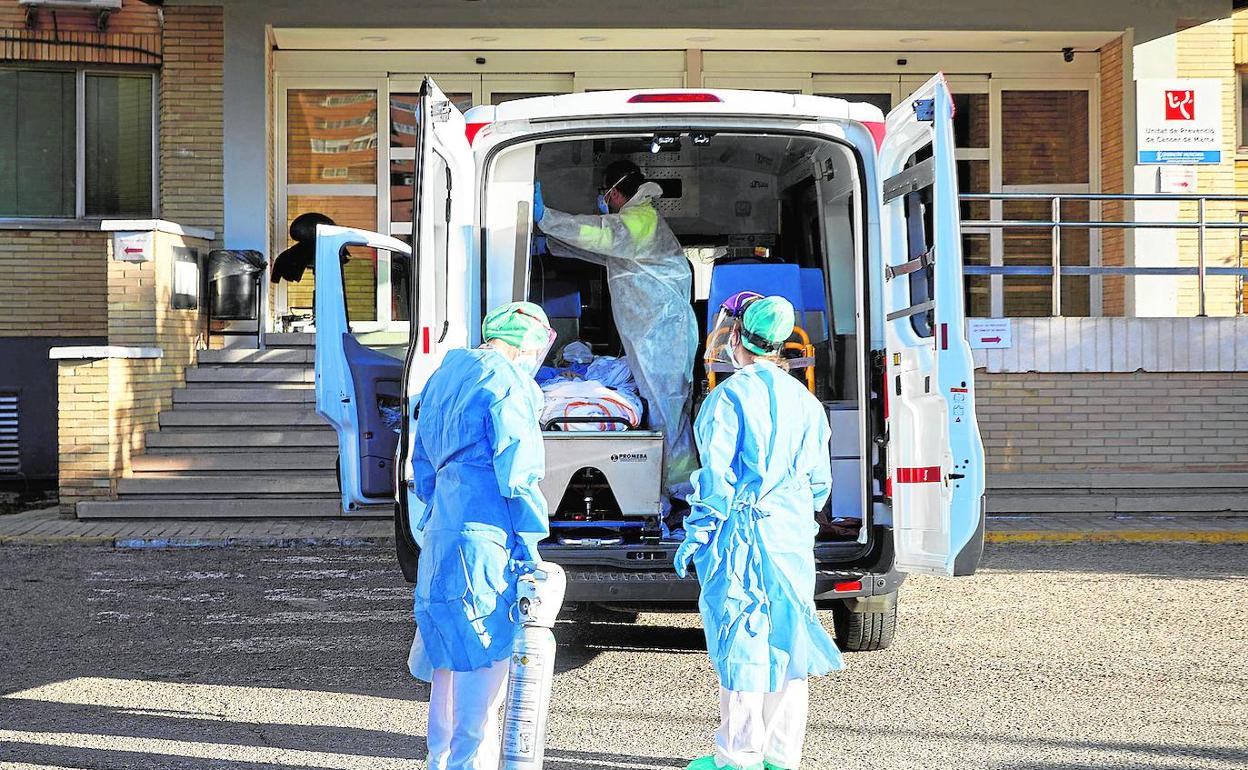 Sanitarios trasladan a un paciente hasta las instalaciones acondicionadas en el antiguo hospital La Fe de Campanar.