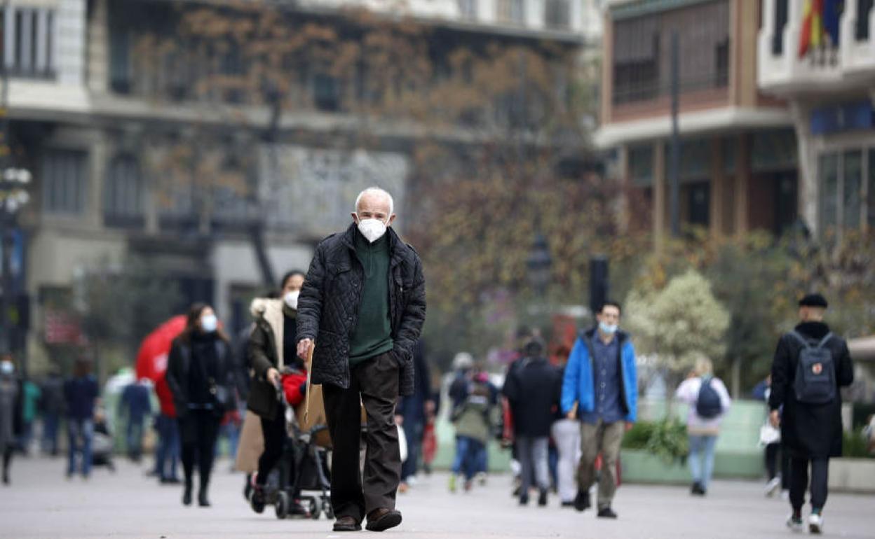 Un hombre pasea con mascarilla por la plaza del Ayuntamiento de valencia.