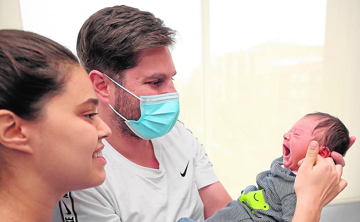 Darío y Agnes miran a su bebé en su habitación de La Salud, a las pocas horas de su nacimiento. 