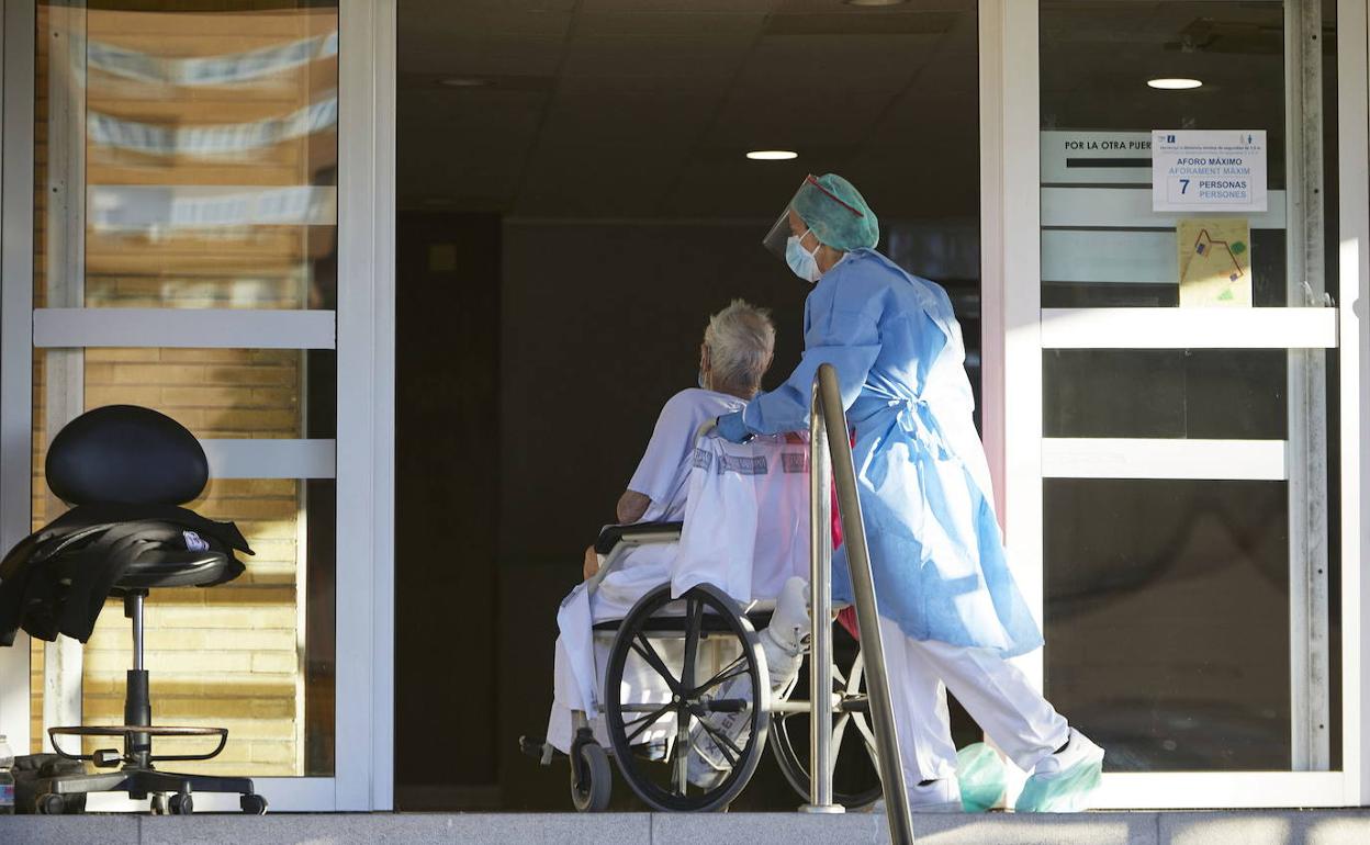 Un sanitario traslada a un paciente de coronavirus. 