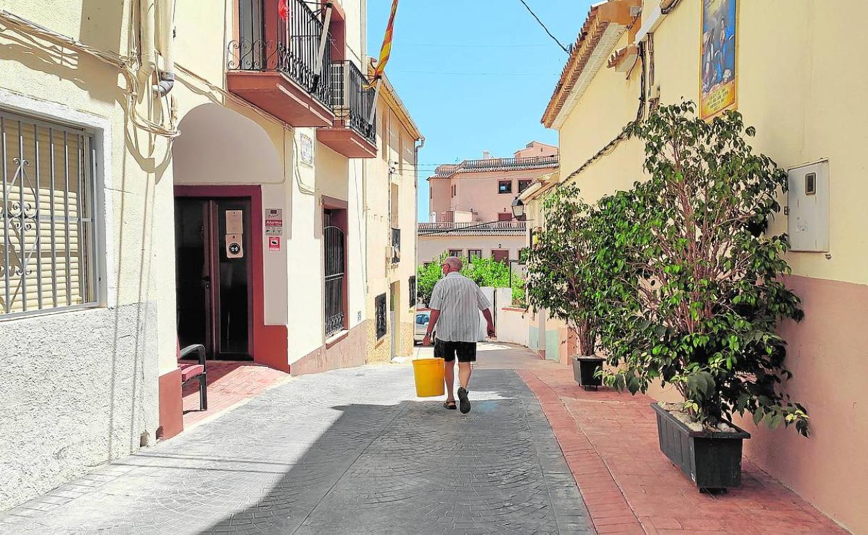 Un vecino de Bolulla pasea por delante de la fachada del Ayuntamiento. 