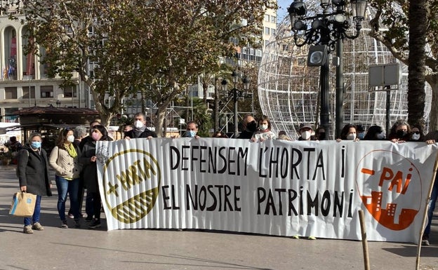 Imagen principal - Pancartas de protesta vecinal y simulación de un huerto cultivado. 