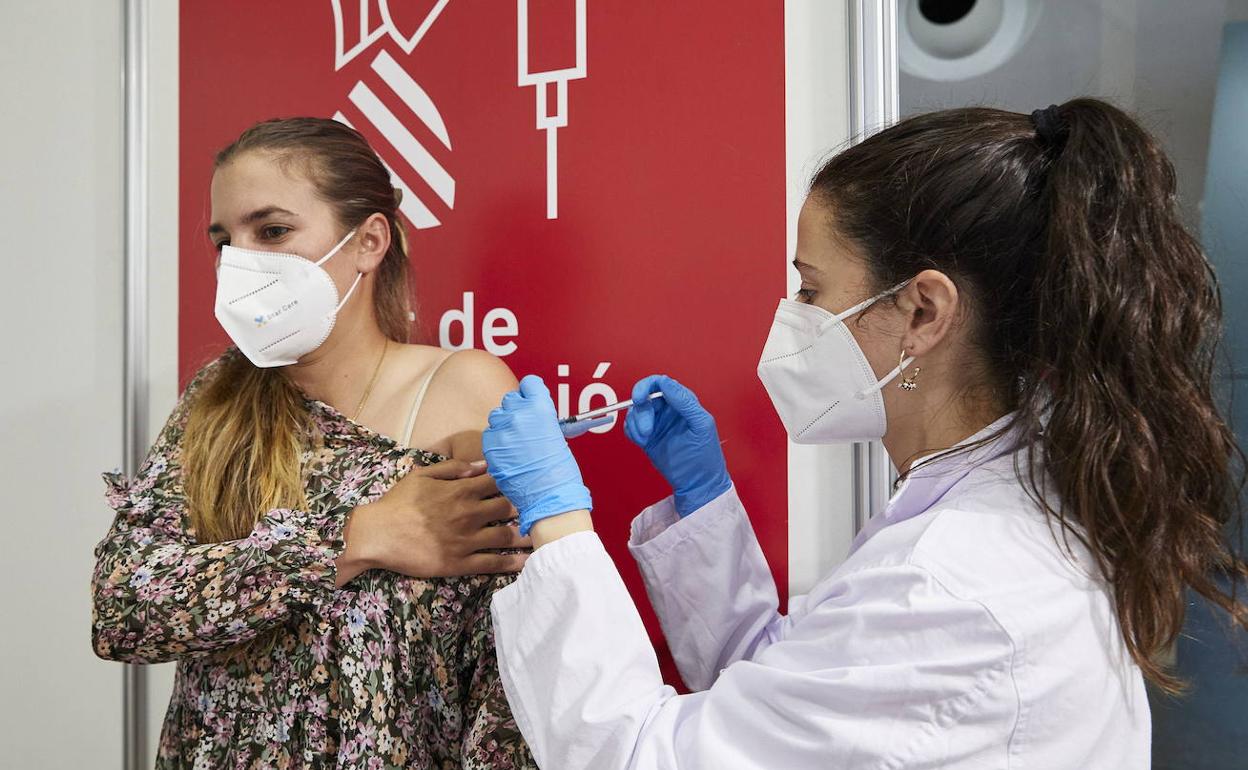 Una sanitaria vacuna a una joven en Valencia. 