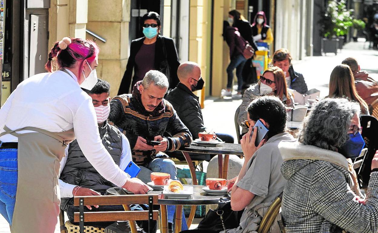 Clientes desayunando en la terraza de un bar, en Valencia. 