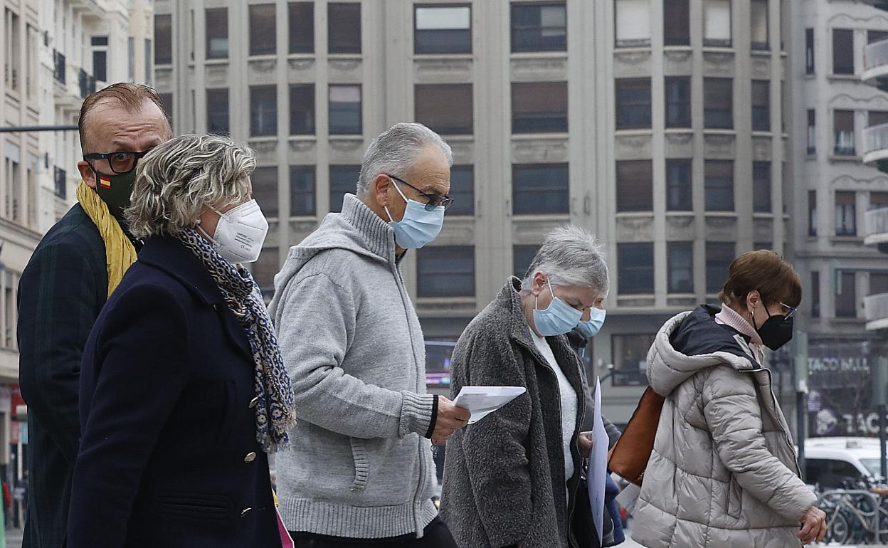 Varios ciudadano se protegen con mascarillas por la ciudad de Valencia. 