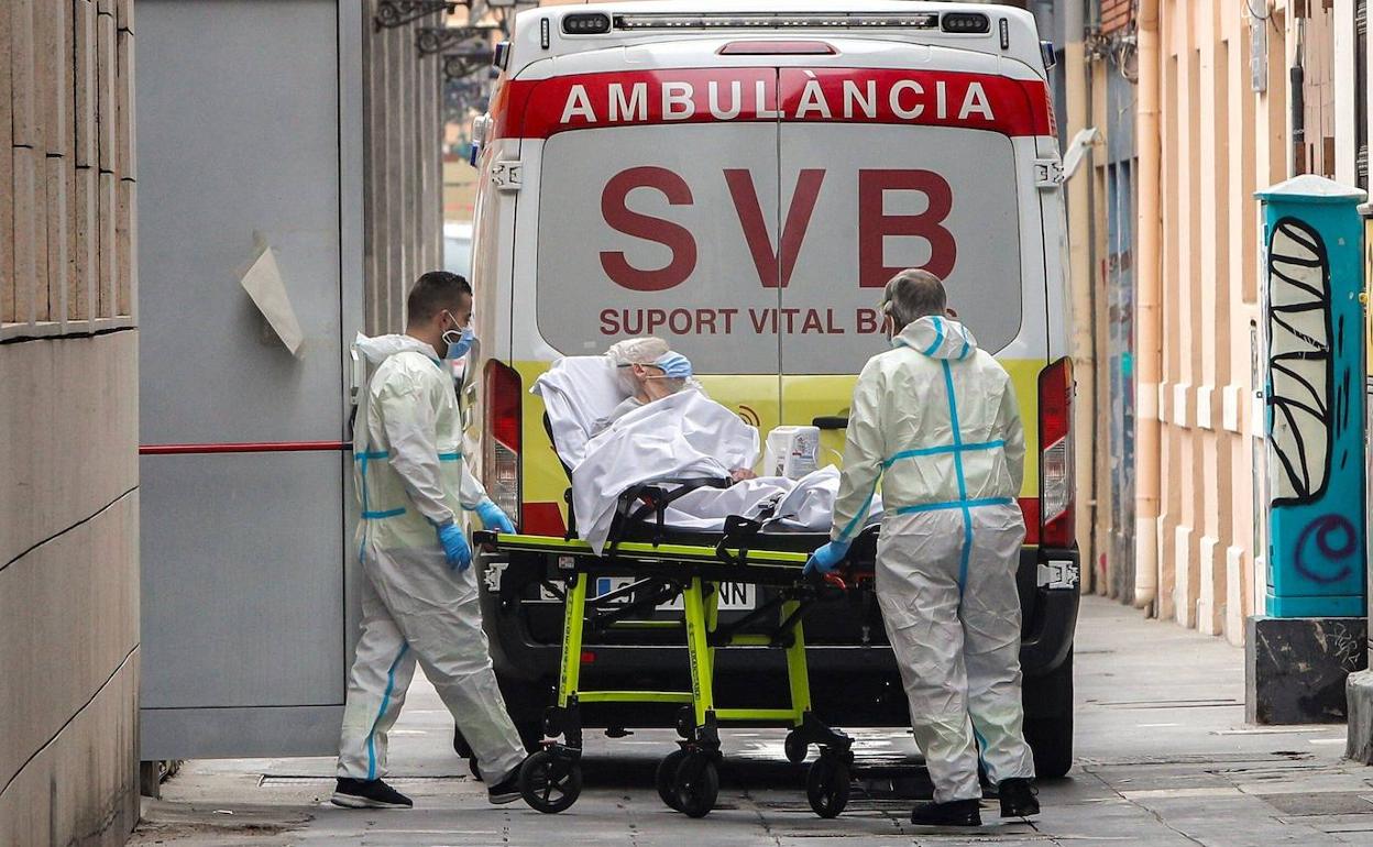 Personal sanitario traslada a un enfermo de Covid de una residencia.