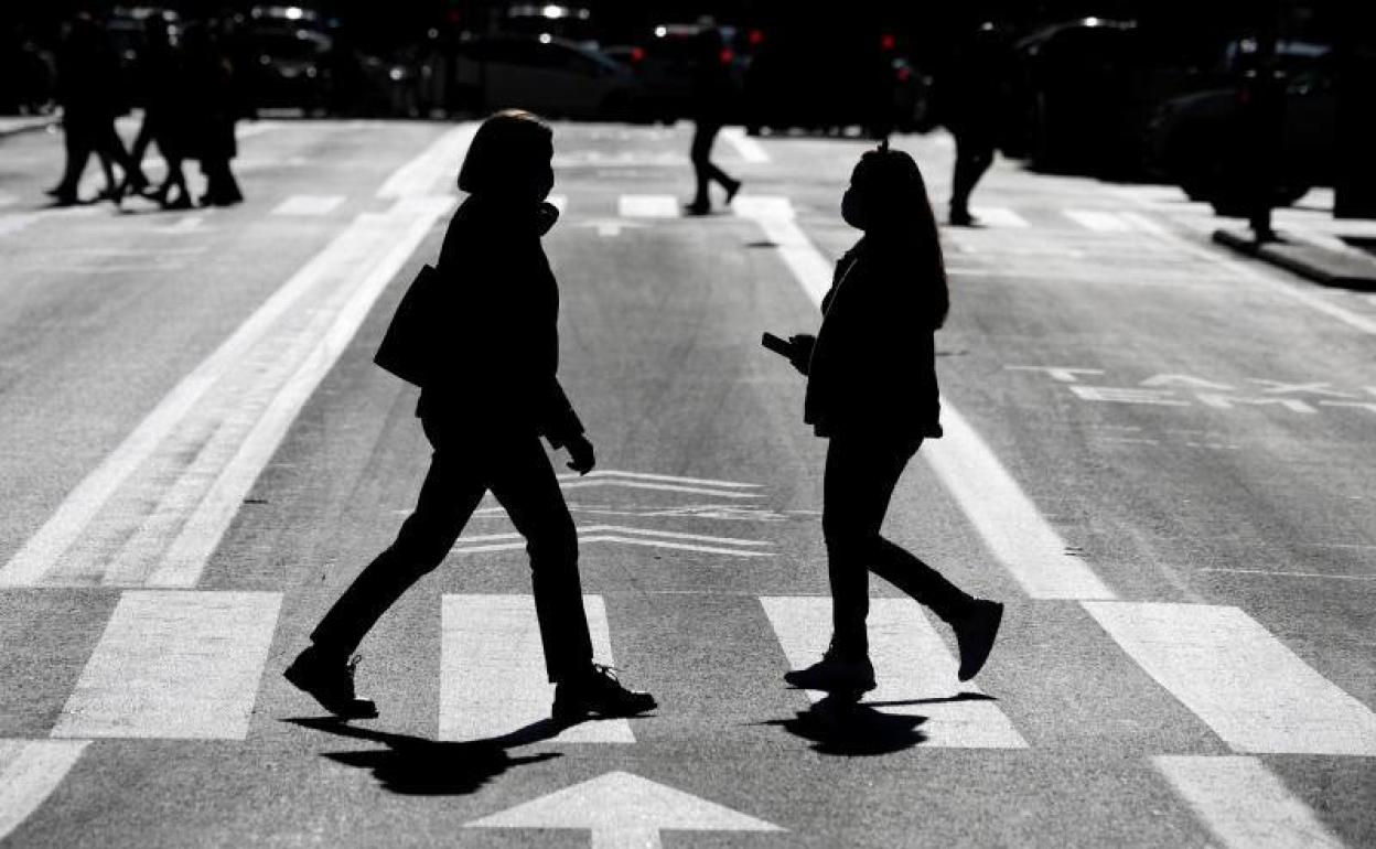 Dos mujeres pasean por Valencia con mascarilla