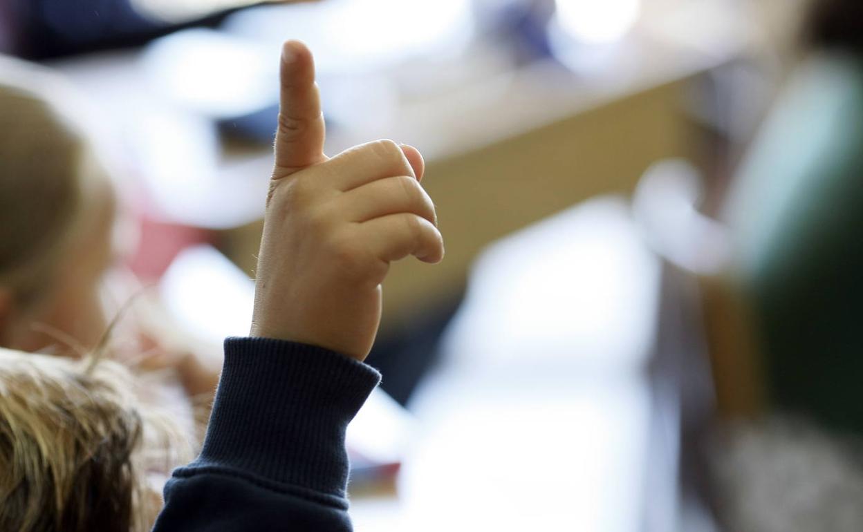 Un alumno levanta la mano durante una clase, en una imagen de archivo. 