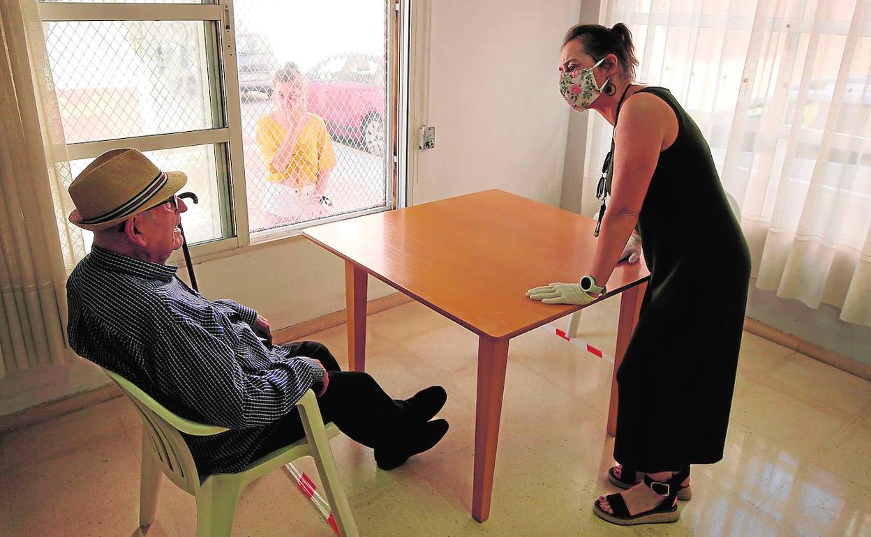 Una mujer charla con un familiar en el geriátrico de Alzira. 