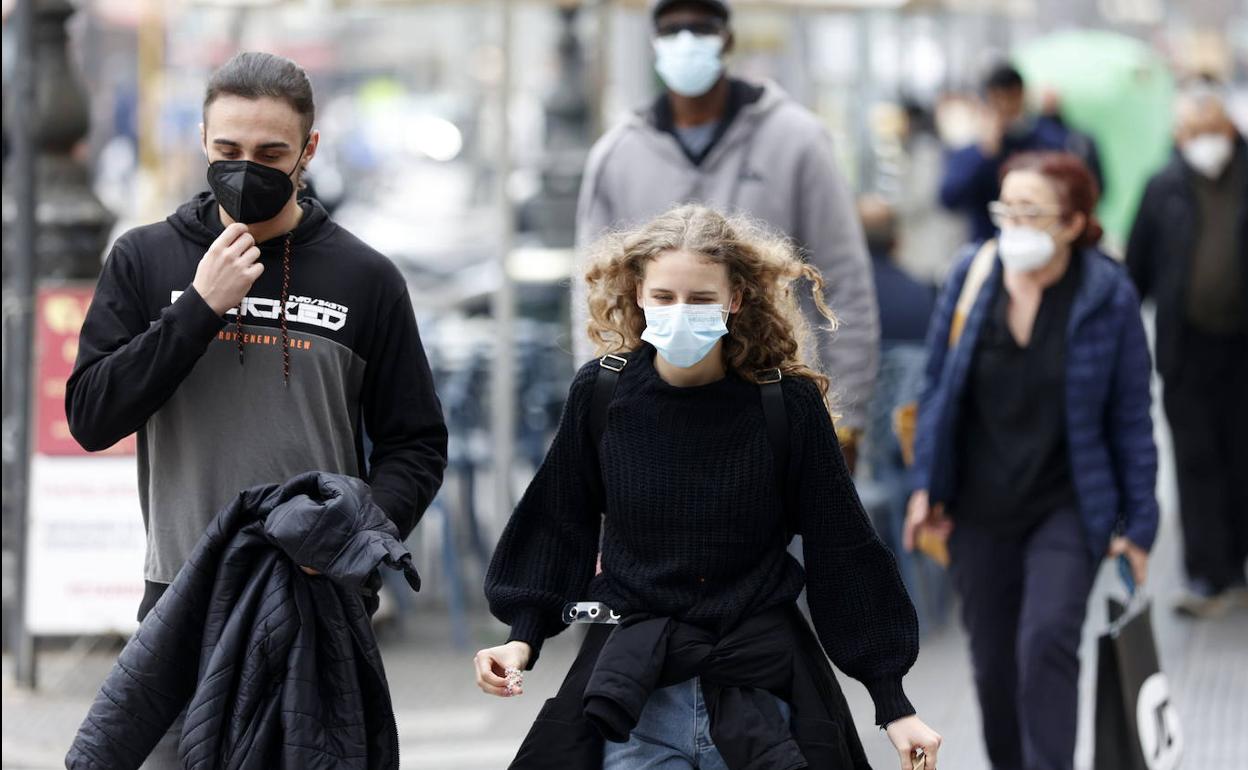 Personas caminan con mascarilla en Valencia.