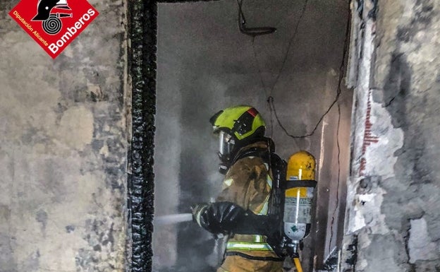 Un bombero apaga el fuego declarado en la vivienda de Orihuela este domingo. 