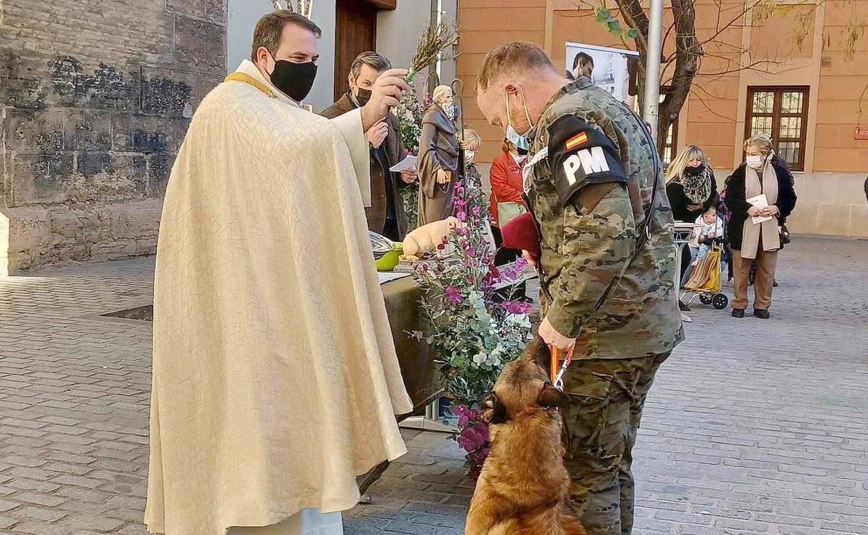 El capellán de la sede Santa Úrsula, Daniel Rieger, bendice al perro de un miembro de la Policía Militar.